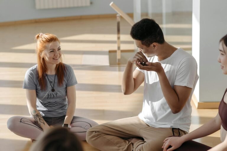 A diverse group of adults enjoying a yoga session in a bright, sunlit room.