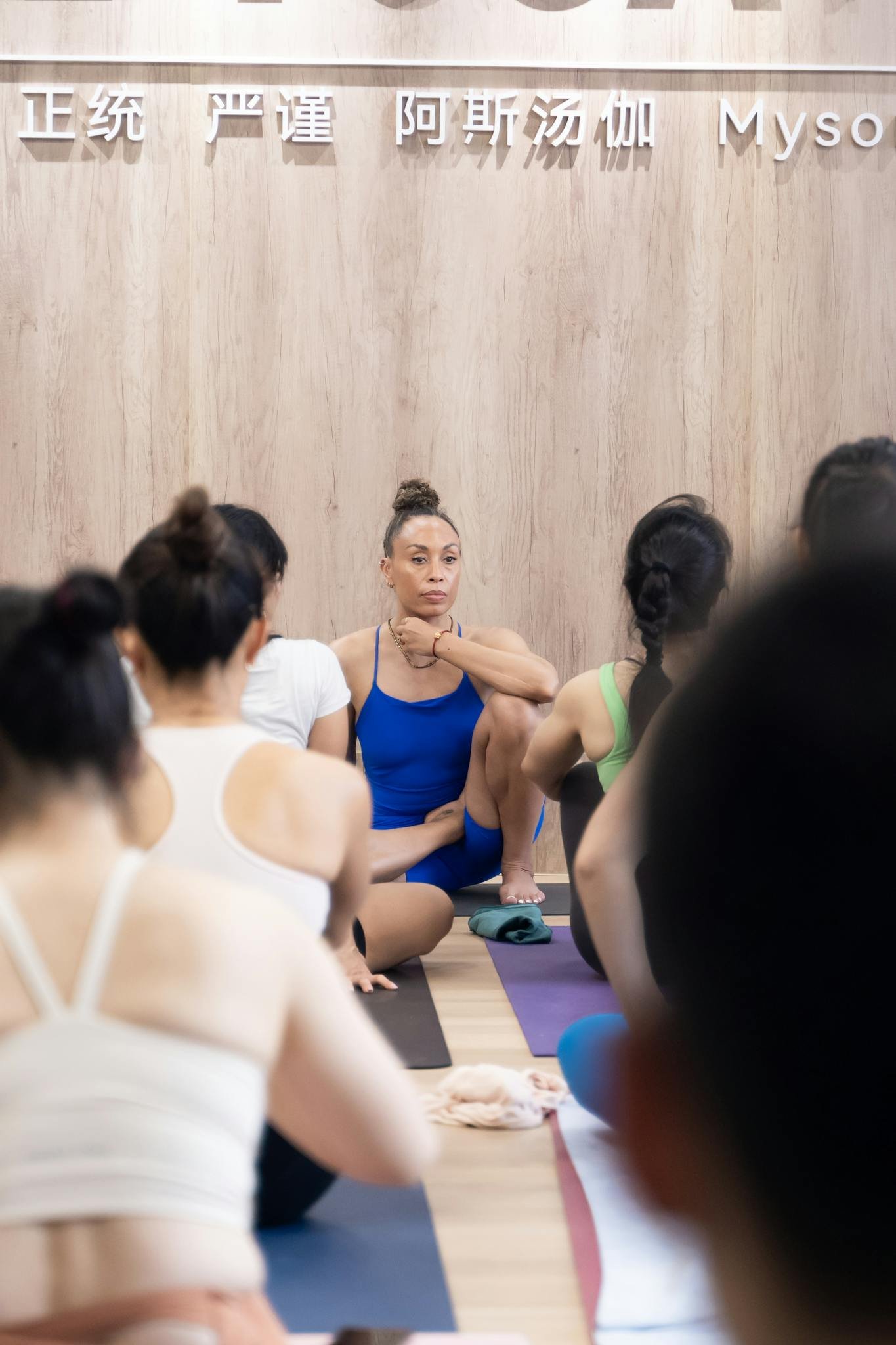 Group of women in a yoga class focusing on breathing and relaxation indoors.